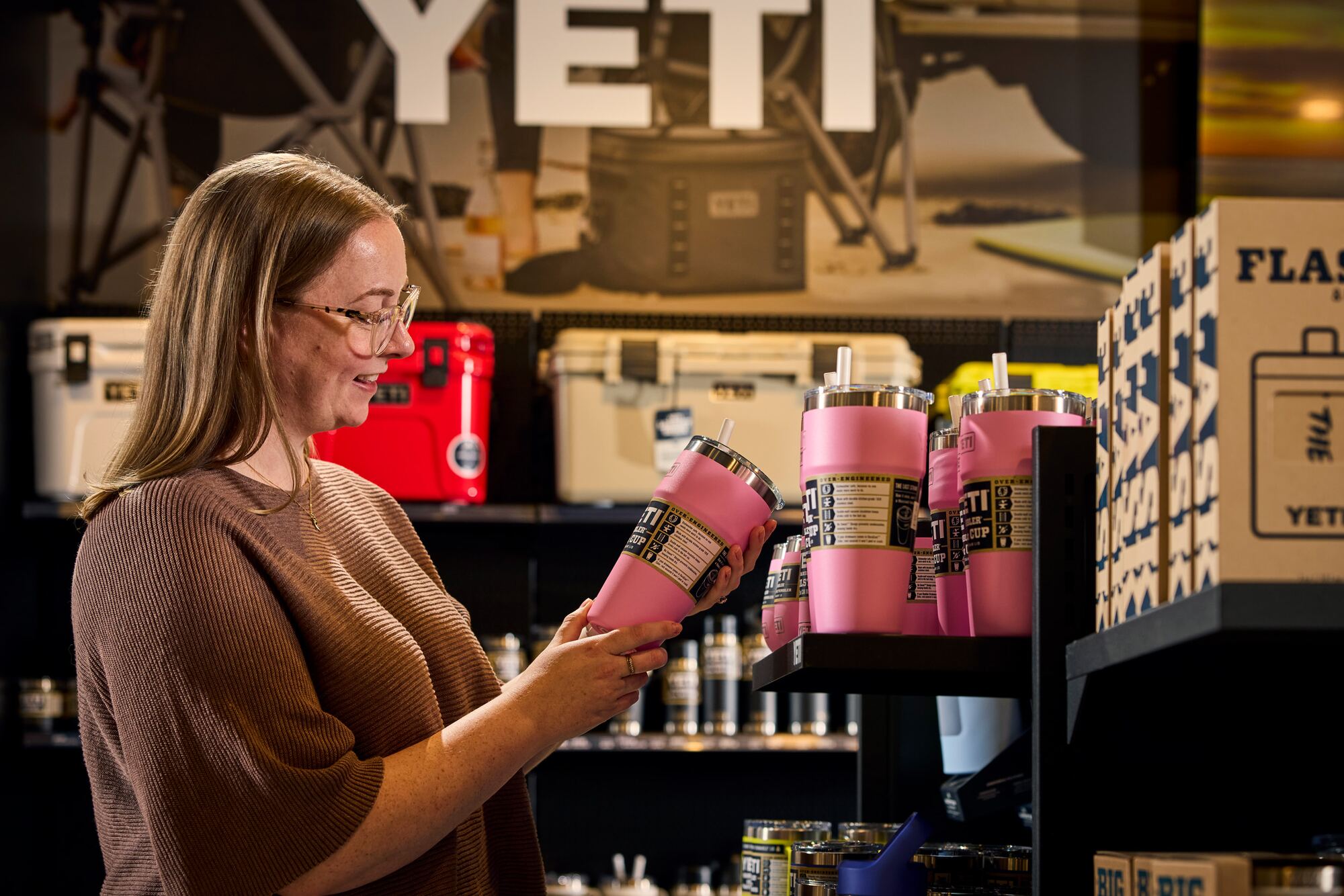 A customer holding a pink YETI tumbler in the showroom